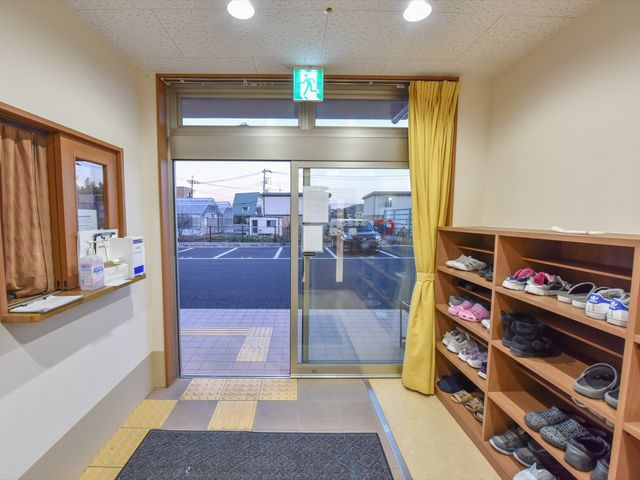 エントランスの靴棚と出入口 玄関 清潔感のあるエントランスは、手洗いの設備が整っており来訪者の衛生管理に配慮されています。靴棚は段差を解消し安全に配慮した作りです。