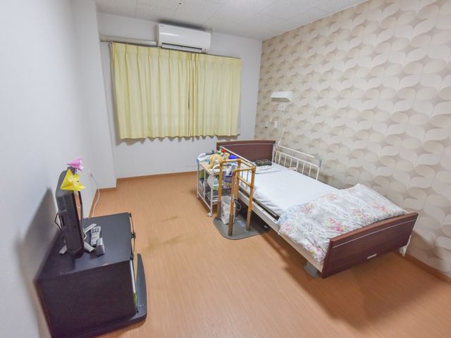 個室の居心地の良さ 居室 余裕を持った広さの個室で、落ち着いた壁紙が特徴的です。日常生活に必要な家具が整っており、快適に過ごせる工夫がされています。