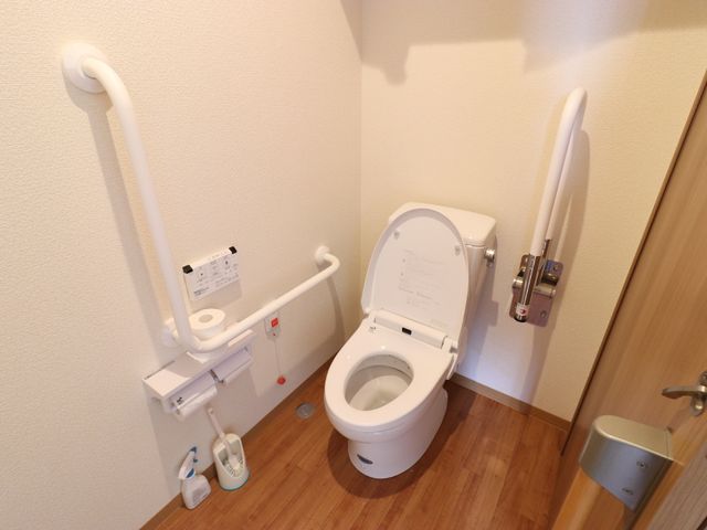 手すり付き清潔なトイレ トイレ 安全性に配慮した手すりが備えられたトイレです。利用者の自立支援と安全のために設計されています。