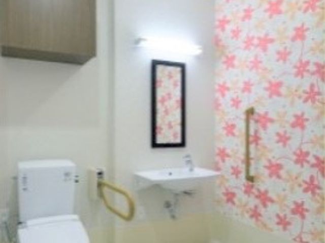 和風デザインの清潔なトイレ トイレ 手すり付きで安全に配慮された和風のトイレ空間です。柔らかな色合いで落ち着いた雰囲気を提供しています。