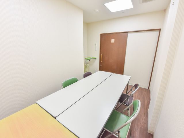 シンプルな居室の風景 面談室 清潔感のある居室では、大きなテーブルとイスが配置され、ゆったりとした時間を過ごせるよう整えられています。