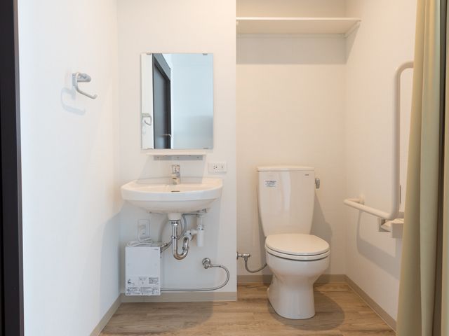 バリアフリー対応の洗面トイレ トイレ  手すりが設置された清潔感のあるトイレです。利用者の安全と快適性を重視した設計になっており、就業する方にも配慮が行き届いた環境です。