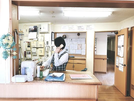 受付で電話応対するスタッフ