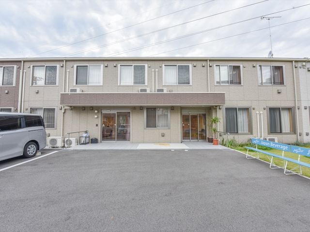 ゆったりとした外観の建物 外観 落ち着いた色合いの外観が、温もりと安心感を与える空間を提供いたします。大きな窓は十分な採光を確保しております。