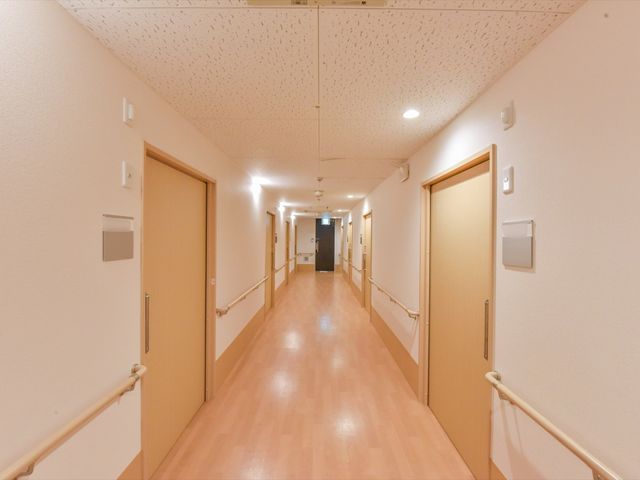 清潔な施設の廊下 廊下 手すり付きの廊下は広く、安心して歩行できる設計です。明るく清潔感があり、居心地の良い環境が保たれています。