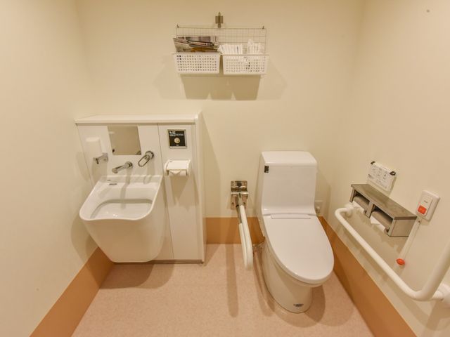 バリアフリー対応の洗面所 トイレ 安全に配慮された設備が整った清潔なトイレです。手すり付きで利用しやすく、快適な環境が提供されています。