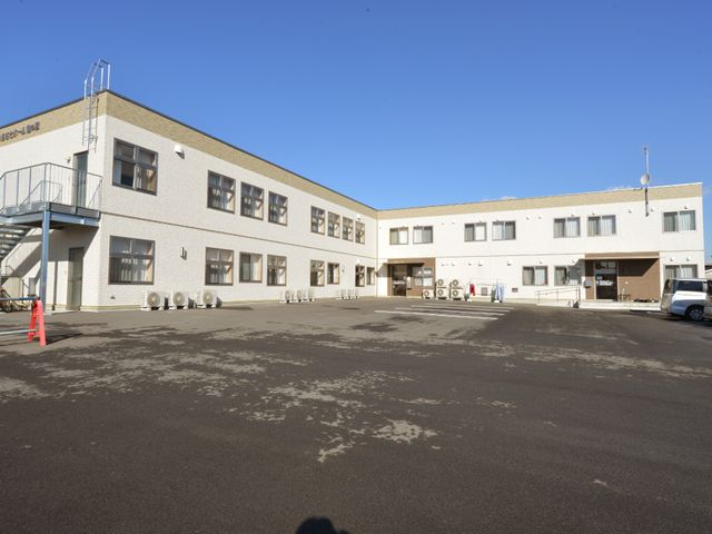 広々とした白い外観 施設外観 明るく広い敷地を持つ施設で、利用者様の快適な毎日をサポートします。設備が整った環境でのお仕事にご関心をお持ちでしたらお待ちしております。