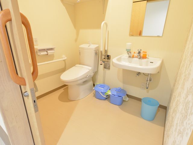 バリアフリー設計の洗面台トイレ トイレ 手すり付きで安全に配慮された清潔なトイレです。使いやすさを考えた設計で、安心して過ごせる環境が整っています。