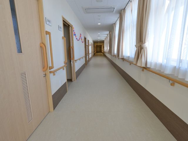 明るい廊下の風景 廊下 手すりが設置された明るく清潔な廊下です。訪れる方々の快適な移動が支援されています。