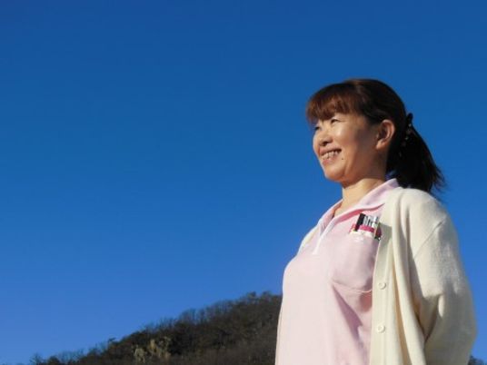 明るい空に笑顔の女性