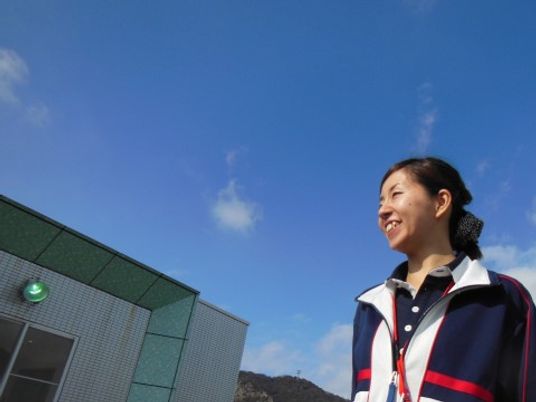 青空背景に笑顔のスタッフ