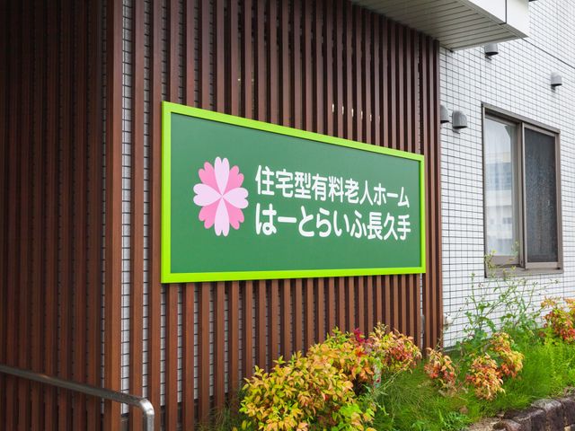 看板の情景 看板 落ち着いた雰囲気の中に設置された緑色の看板です。自然に囲まれた優しい印象を受けます。