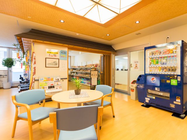 リラックスできる休憩スペース 売店とその前の空間 開放的な空間で快適な休息が可能です。カラフルな椅子が明るい雰囲気を醸し出しています。