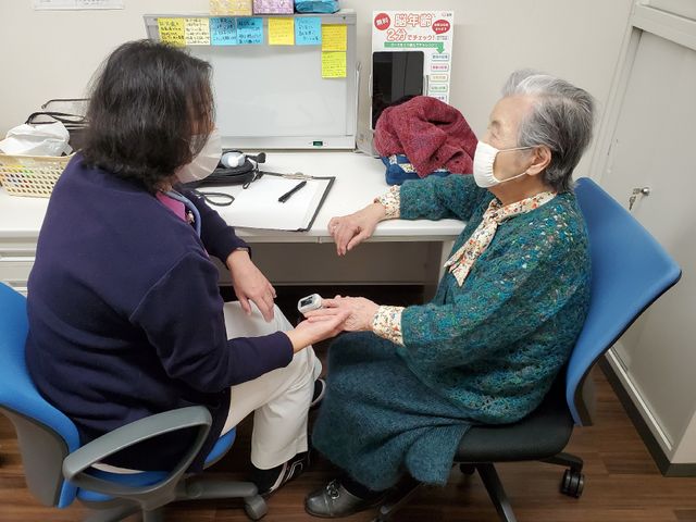 ケアスタッフと利用者の対話 健康相談 親切なスタッフが利用者の方とじっくりと向き合い、心の通ったケアを提供しています。明るい空間で、信頼関係を築きながらサポートを行っています。