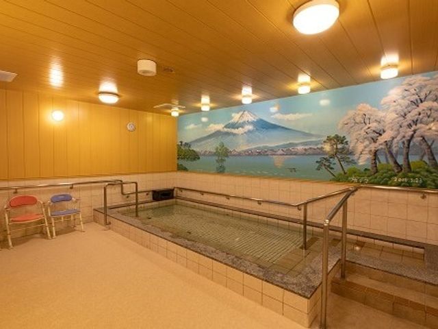 和風デザインの浴室 共同浴室 富士山が描かれた壁画に囲まれた温もりのある空間です。手すりも完備され、安心して利用できる造りになっています。