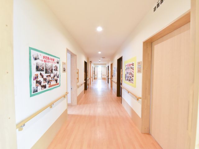 明るく広々とした廊下 広い廊下 手すりが設けられた廊下は、清潔感があり明るい雰囲気で、ご利用者の移動も安全に配慮されています。壁に掲示物があり、活動の様子を伺い知ることができます。