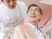 笑顔の高齢男性と介助者