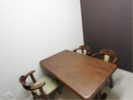 木製テーブルと椅子が並ぶ居室