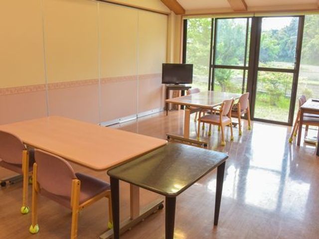 テーブルと椅子のある部屋 リビング 開放感のある窓際に配置されたテーブルセットで、穏やかなひとときを過ごせる場所です。自然光が差し込む落ち着いた空間が広がっています。