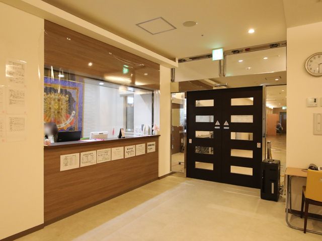 受付と廊下の広々空間 受付カウンター 開放的なフロントエリアは、来訪者を温かく迎え入れる設計です。働くスタッフの様子も伺え、コミュニケーションが活発に行われています。