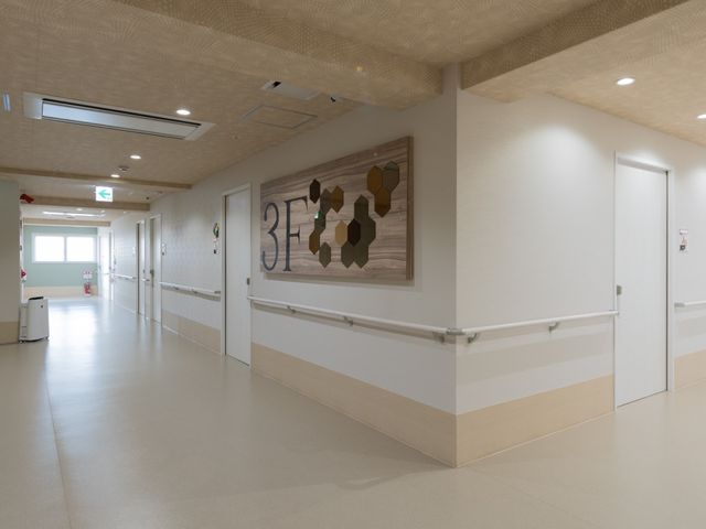 清潔感ある施設の廊下 廊下 ゆとりある通路が確保された明るい空間です。手すり沿いに歩く方々の安全を支えています。