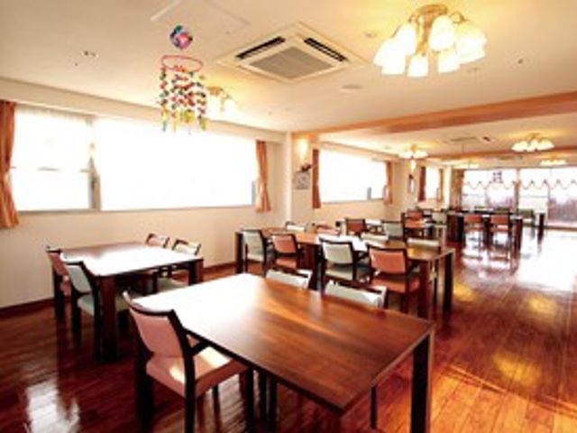 明るい食堂のテーブル席 食堂   窓から自然光が入る、ゆったりした食堂です。木目の床と整ったテーブル席があり、落ち着いて食事をしやすい雰囲気です。