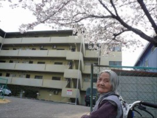 笑顔で外を眺める利用者と外観