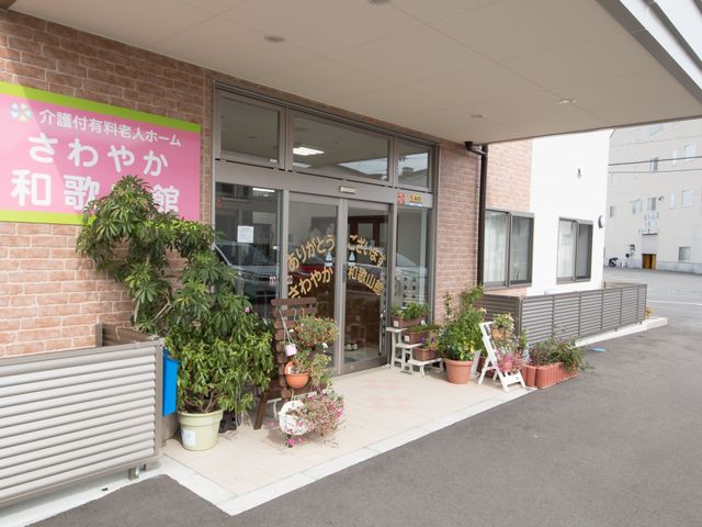 花で彩られたエントランス 外観 エントランスには季節の花々が飾られ、訪れる人を暖かく迎えています。清潔感があり、安心して過ごせる環境が整っています。