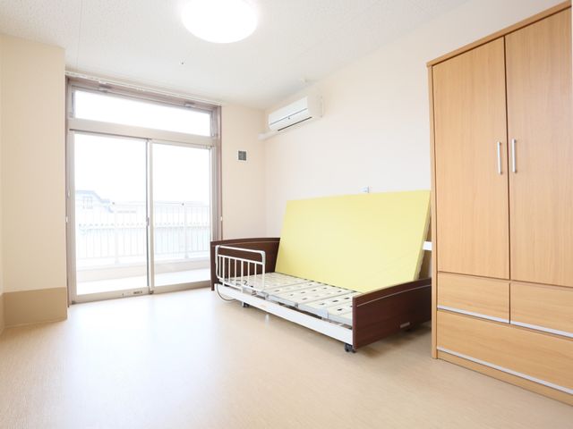 明るい個室の居室 居室 ゆったりとした個室で、大きな窓からは自然光が差し込みます。家具も整えられ、快適な個人空間が確保されています。