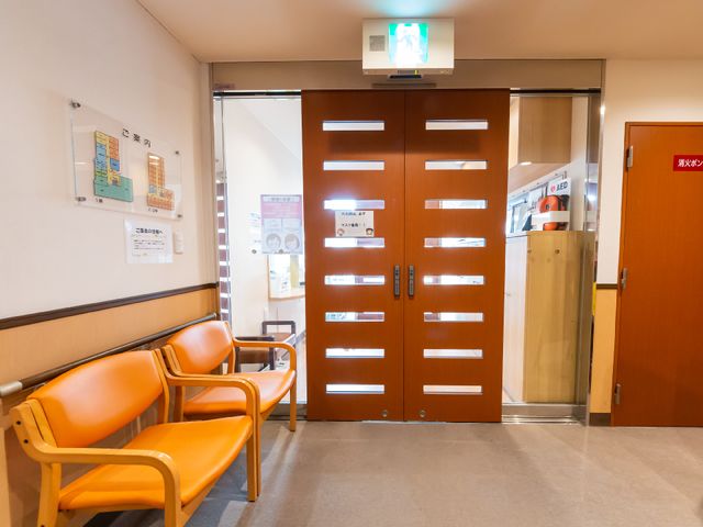 エントランスの様子 玄関 落ち着いた色合いの待合室が確認できます。AED設置を含む安全対策が整っており、安心して勤務できる環境です。