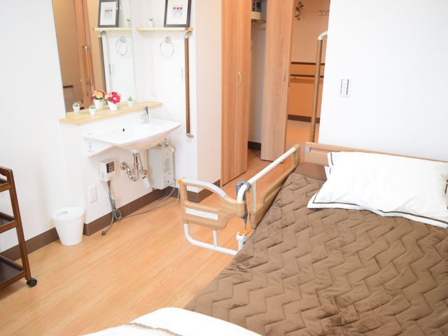 居室のベッドと洗面台 モデルルーム ゆったり過ごせる居室です。必要な設備が整い、安全に配慮された造りとなっており、快適な毎日をサポートします。