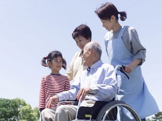 車椅子のおじいさんと笑顔の家族