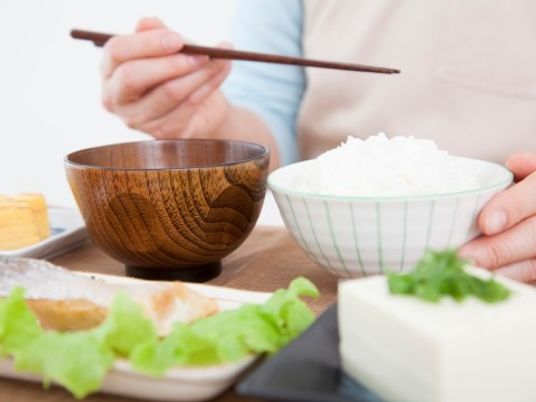 手前に食事、人物は手元焦点