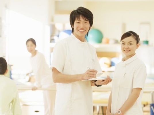 スタッフが微笑むリハビリ室