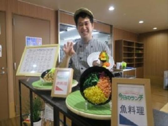 笑顔のスタッフと食事模型