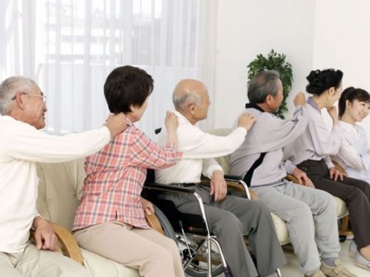 笑顔で肩たたき活動中の利用者