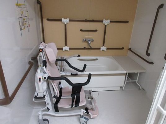 「静岡ケアハートガーデン新伝馬」の浴室。シャワーチェアを配置したり、壁には手すりを多く設けている。