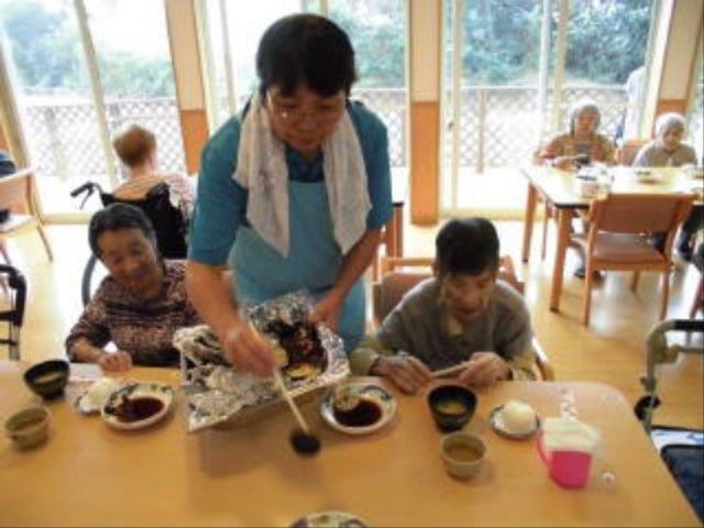 食事の支度をするスタッフ 共有スペース スタッフが手作りのお食事を提供し、利用者の方々は明るいダイニングで笑顔で食事を楽しんでいます。