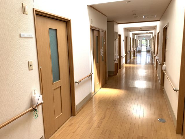 長い木製の廊下 廊下 温かみのある木の床で、自然光が降り注ぐ長い通路です。明るく清潔感がありますので、安心してご利用いただけます。