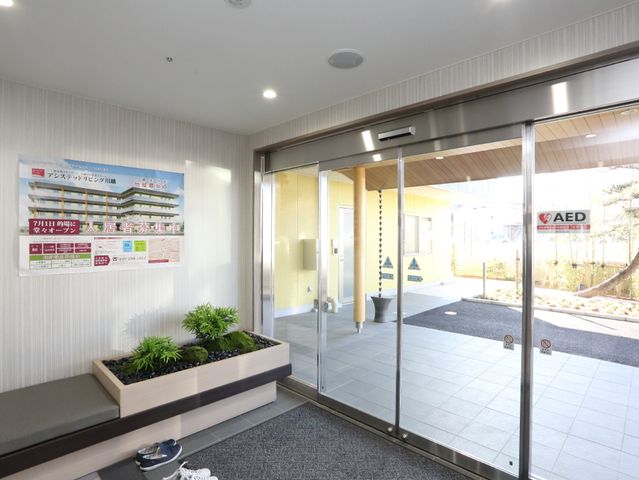 明るいエントランスの様子 玄関 ガラス扉を通じて光が差し込むエントランスは、訪れる方々を暖かく迎え入れます。安全配慮も行き届いており、AEDの設置もあります。