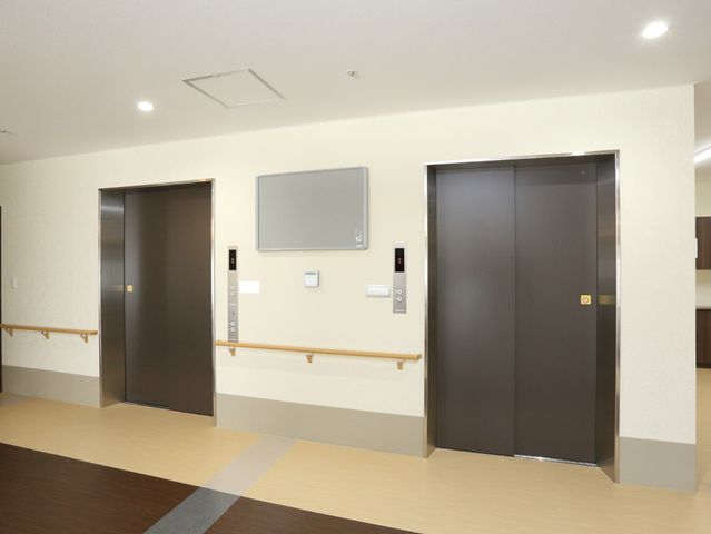 清潔なエレベーター廊下 エレベーター 床には滑りにくい素材が使用され、壁沿いに手すりが設置されており、歩行に不安のある方も安心です。明るく広々とした廊下は、日々の移動も快適に行えます。