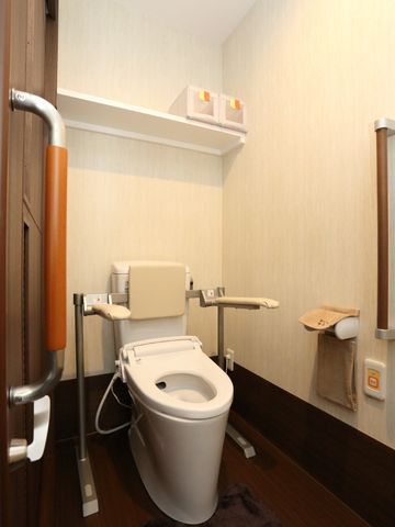 バリアフリートイレ設備 トイレ 手すり付きで安全性を考慮したトイレです。余裕を持った動線で、サポートが必要な方も安心してご利用いただけます。