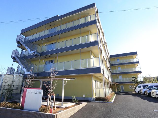 黄色い外壁の建物外観 外観 明るい色彩の外壁が印象的な施設外観です。清潔感があり、心地よい環境でのお仕事をご検討ください。
