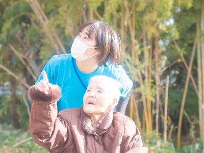 外の光浴びる高齢者と職員