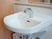 サムネイル 洗面台のアップ画像。白く清潔に保たれている様子が分かる。自動で給水止水ができるタイプで、鏡や小物を置く台も付いている。