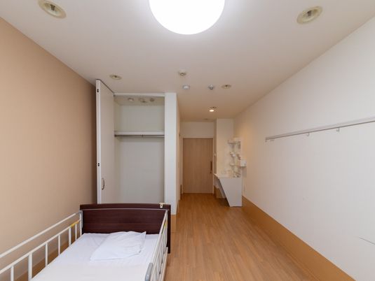 ベッドと洗面台のある居室  