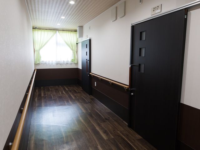 廊下の光景 廊下 手すり付きで清潔感ある通路を備え、居心地の良い空間が保たれています。働く環境として快適な場所です。