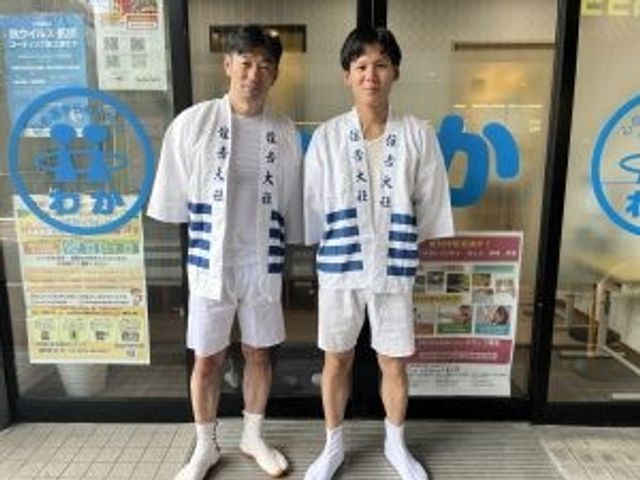 スタッフが立つエントランス エントランス   明るい出入口の前にスタッフの方が立っています。来訪者を迎える様子が伝わり、職場の雰囲気をイメージしやすいです。