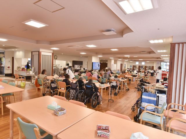 明るい共有スペース 食堂 広々とした食堂です。利用者様が集い、明るい雰囲気の中で交流を楽しむ様子が伺えます。