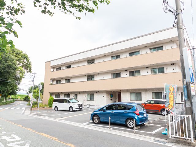 清潔感のある4階建て建物 外観 広々とした外観の建物で、周囲には緑が多く、日々の業務にも安らぎを感じられる環境です。駐車スペースも完備しており、通勤にも便利な立地となっています。